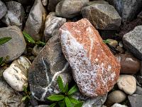 Rostfarbener und dunkler Stein mit weißen Inklusionen